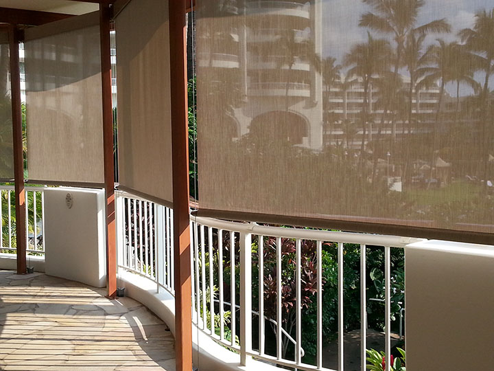 screen shades pulled down over railing overlooking palm trees and resort